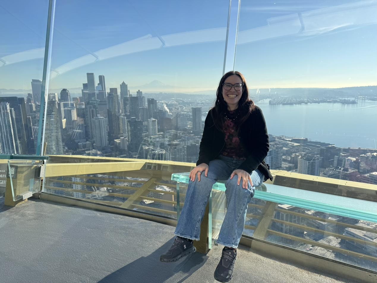 Kat Jong, MD at the Space Needle observation deck with the Seattle skyline behind